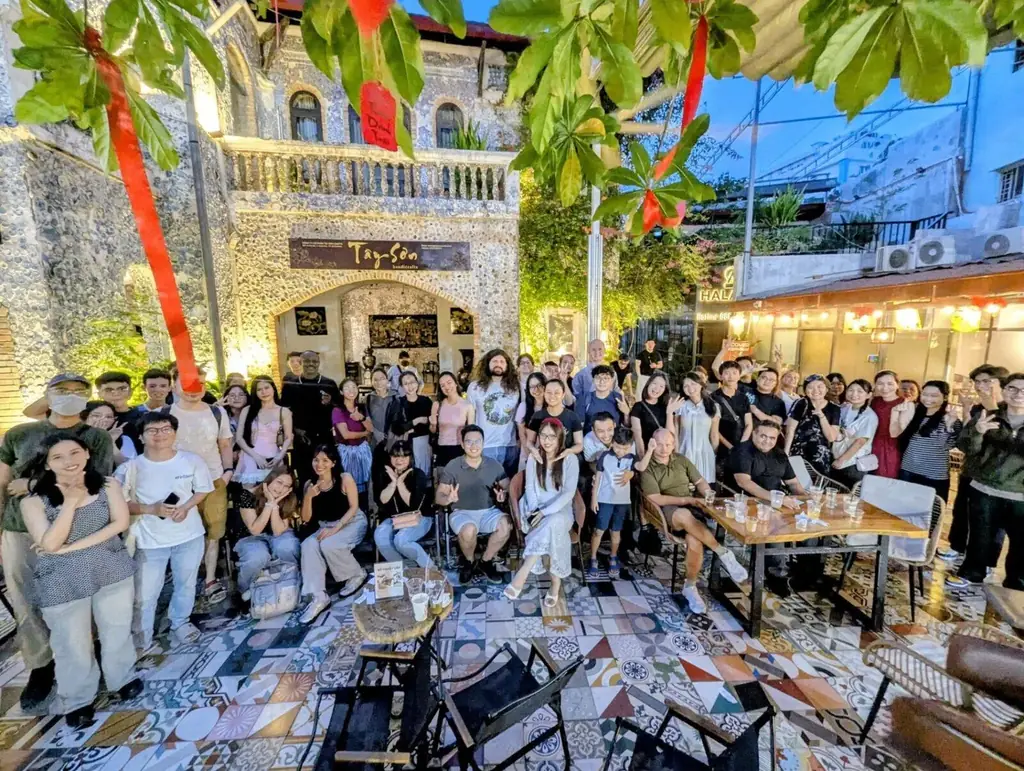 Buổi gặp Buddies Club tại Tayson Cafe Sài Gòn — đông đảo người Việt và bạn bè quốc tế chụp ảnh nhóm