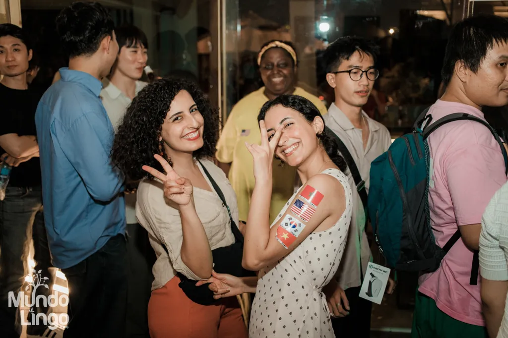 Hai cô gái dán sticker cờ Hàn Quốc, Mỹ, Maroc, Việt Nam trên tay tại Mundo Lingo Saigon