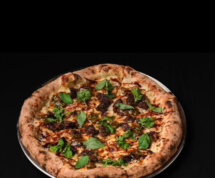 Pizza Merguez xúc xích cay rưới sốt và rau thơm tại Amano Pizza, Quận 1