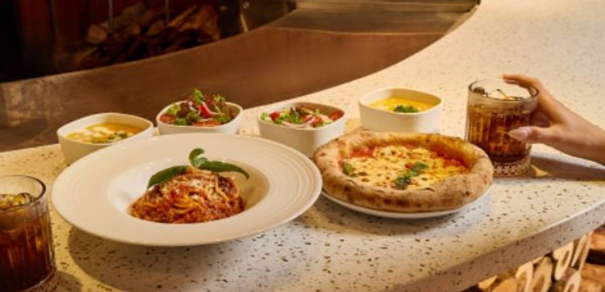 Bàn ăn với pasta sốt cà, pizza lò củi và soup bên lò Napoli tại Italiani's Pizza